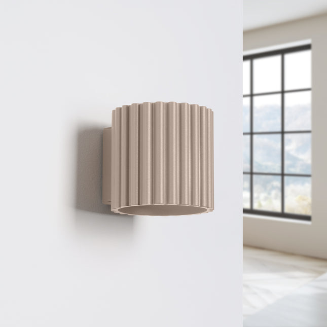 Applique murale Aura taupe installée sur un mur blanc de chambre près d'une fenetre