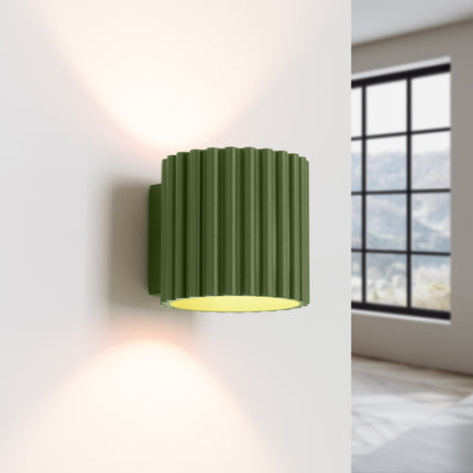 Applique Aura vert olive allumée, double faisceau lumineux vers le haut et le bas sur le mur