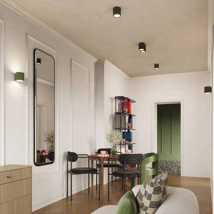 Applique murale Aura vert olive éclairant un intérieur cosy, lumière indirecte