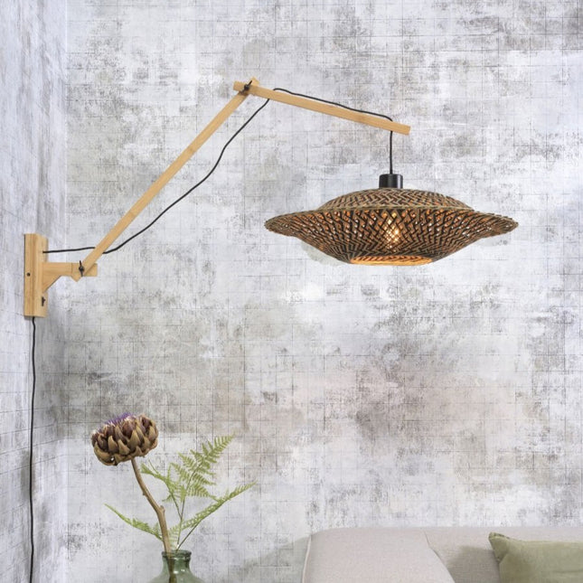 Applique murale Bali en bambou tressé naturel et noir, bras articulé déployé au-dessus d'un canapé beige