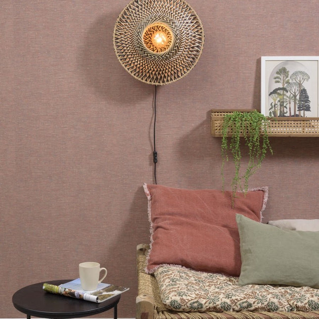 Bali woven bamboo wall light on above a sofa, warm and natural ambiance