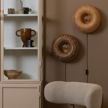 Applique murale en bambou tressé, un coloris naturel et un plus foncé, sur un mur brun chaleureux