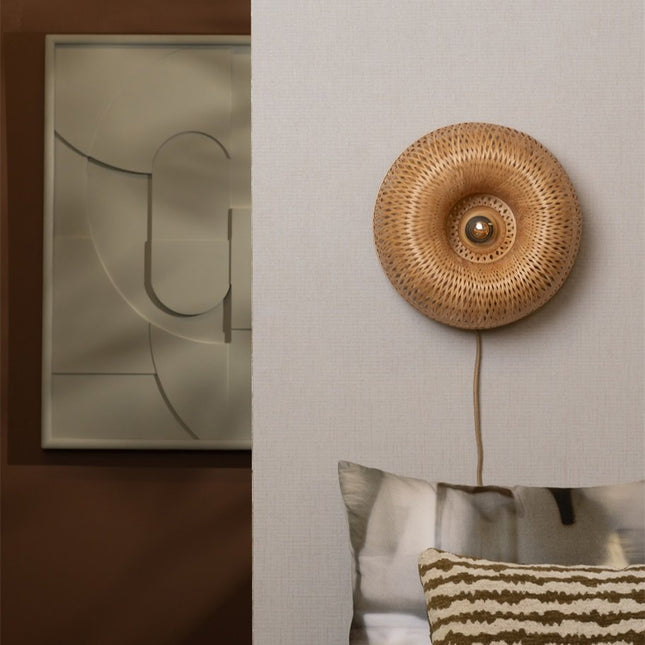 Applique murale Barbados en bambou tressé naturel installée au-dessus d'une tête de lit