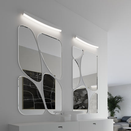 Appliques murales barre courbée blanche au-dessus de miroirs sculpturaux dans une entrée contemporaine
