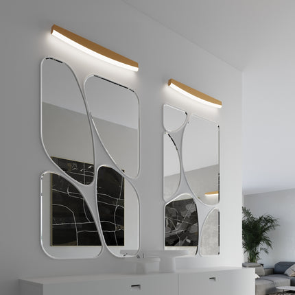 Appliques murales barre courbée dorée au-dessus de miroirs sculpturaux dans une entrée contemporaine