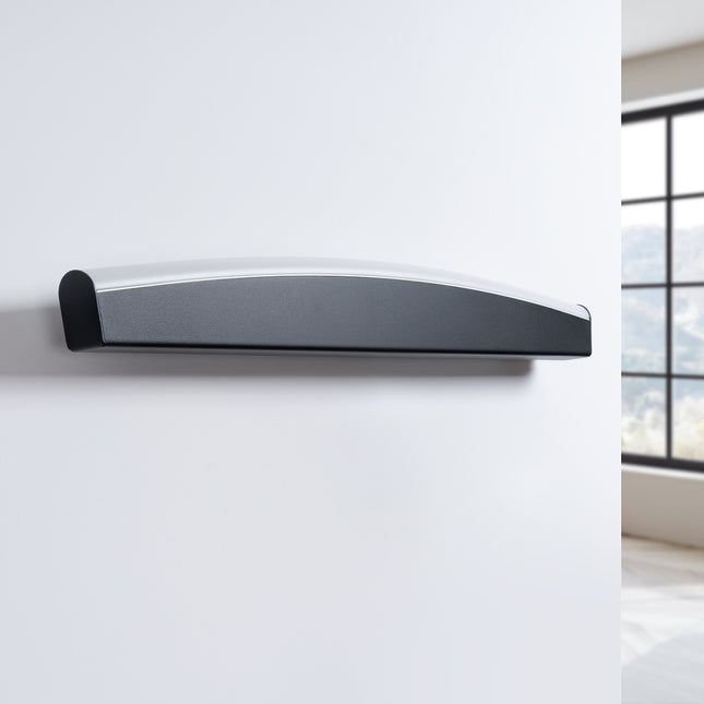 Applique murale barre courbée noire éteinte sur un mur clair, design minimaliste
