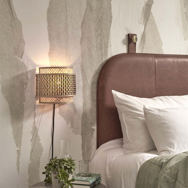 Bhutan wall light installed above a bedside table in a Japandi-style bedroom, leather headboard