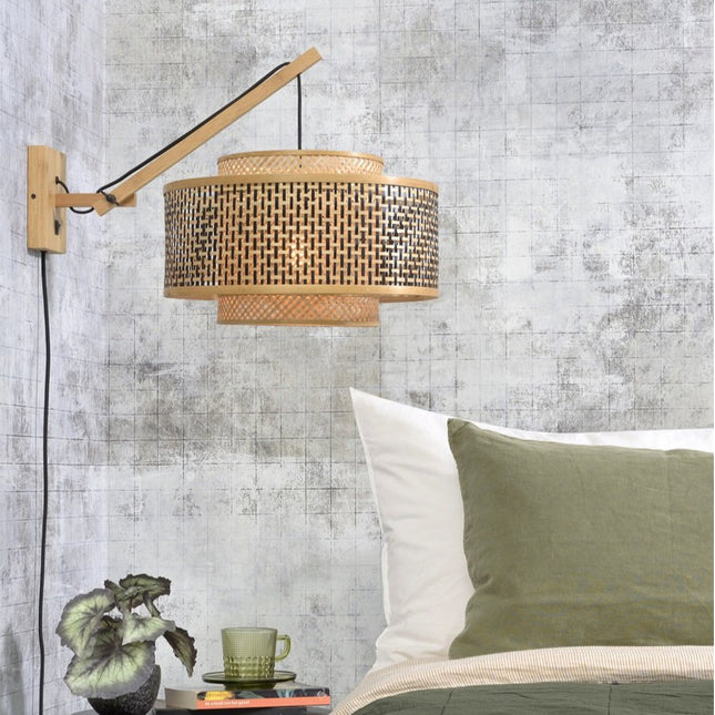 Applique murale Bhutan en bambou tressé naturel et noir, bras orientable, installée au-dessus d'un lit dans une chambre