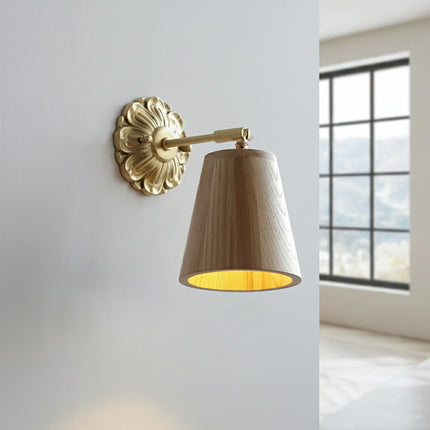 Applique murale en frêne allumée diffusant une lumière dorée à l'intérieur de son abat-jour conique