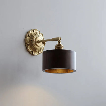 Applique murale en bois foncé et laiton doré avec rosace baroque et abat-jour cylindre sur mur clair