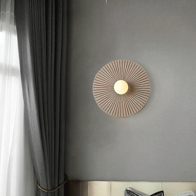 Applique murale en bois massif allumée sur un mur gris, près d'un rideau, ambiance de chambre feutrée