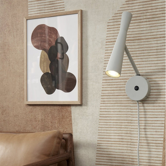 Applique murale Bordeaux en fer gris clair, spot GU10 orientable, dans un salon aux tons naturels