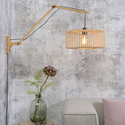 Applique murale Bromo bambou naturel avec bras déplié au-dessus d'un canapé, ambiance salon japandi