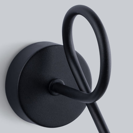 Détail du bras en acier noir formant une boucle décorative, avec sa fixation murale ronde