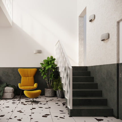 Applique murale céramique gris éclairant un escalier d'entrée dans un intérieur moderne