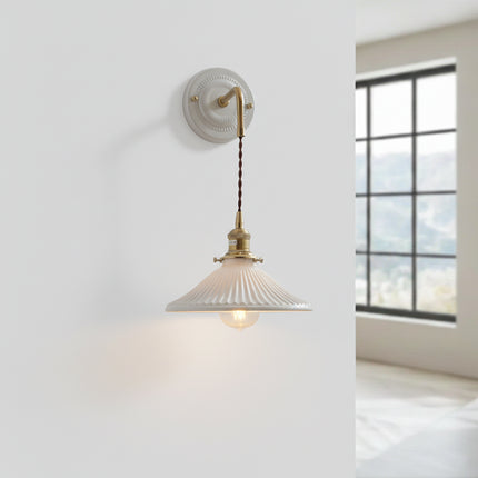 Applique murale suspendue en céramique blanche et laiton, abat-jour évasé le long d'un mur épuré