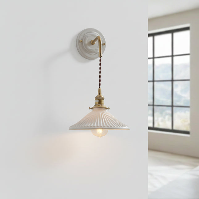 Applique murale suspendue en céramique blanche et laiton, abat-jour évasé le long d'un mur épuré
