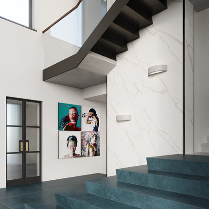 Deux appliques murales croissant en céramique grise le long d'une cage d'escalier design