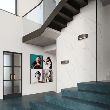 Deux appliques Croissant en céramique noire sur un mur en marbre dans une cage d'escalier