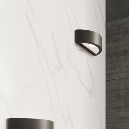 Détail de l'applique Croissant en céramique noire posée sur un mur en marbre clair