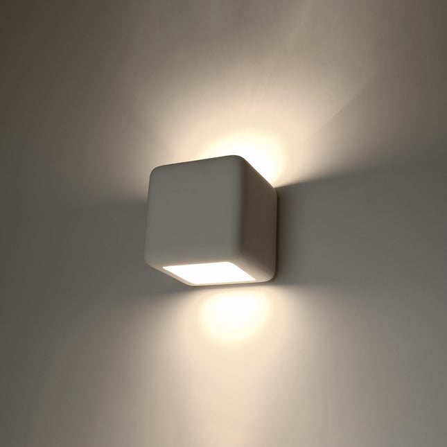 Applique murale cube en céramique blanche allumée, halos de lumière chaude en haut et en bas