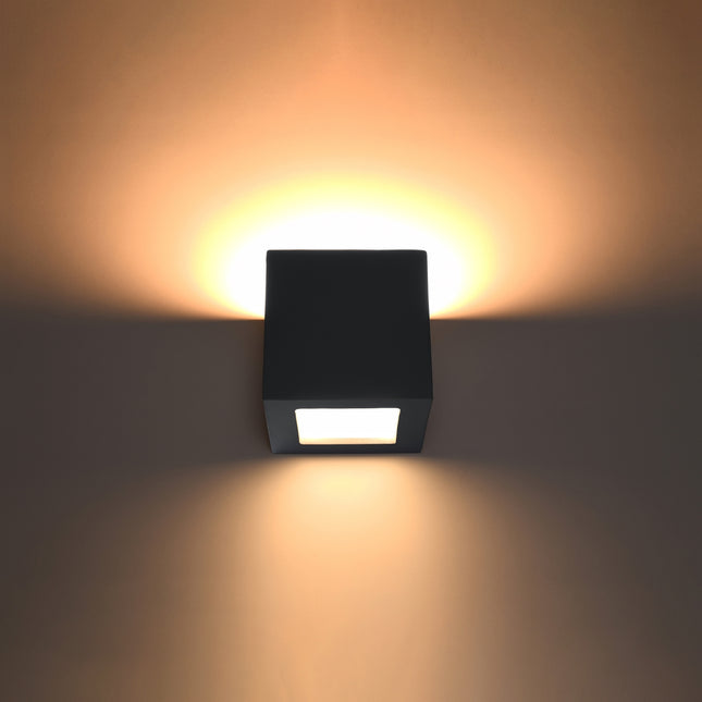 Applique murale Cube noire allumée diffusant une lumière chaude vers le haut et le bas