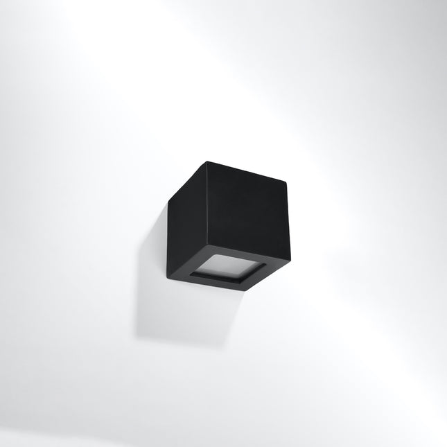 Applique murale Cube en céramique noire mate, vue de trois quarts sur mur clair