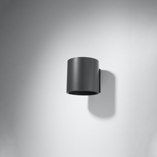 Applique murale cylindrique anthracite fixée sur un mur gris
