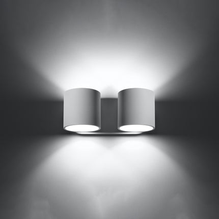 Applique cylindrique double blanche allumée de face, faisceaux lumineux projetés vers le haut et vers le bas.