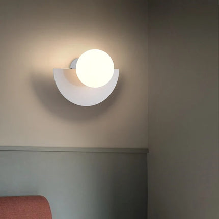 Applique murale LED demi-cercle blanche installée au-dessus d'une tête de lit