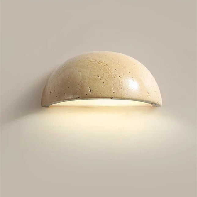 Applique murale demi-cercle en travertin naturel beige diffusant une lumiere chaude sur un mur