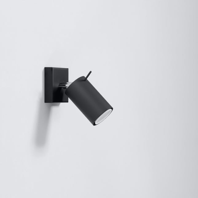 Applique murale directionnelle à spot orientable en acier noir dans un salon