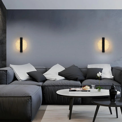 Paire d'appliques murales disque de part et d'autre d'un canapé gris dans un salon minimaliste