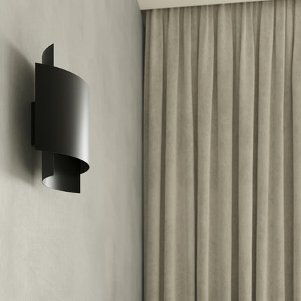 Detail de l'applique murale double arc en acier noir mat pres d'un rideau