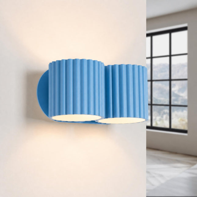 Double Aura wall light in sky blue, lit, four beams up and down
