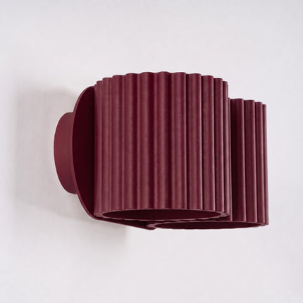 Applique Murale Double Aura bordeaux sur fond coloré, vue de trois quarts