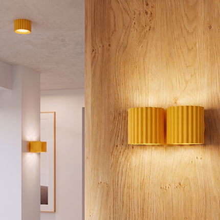 Applique Murale Double Aura jaune dans un couloir clair