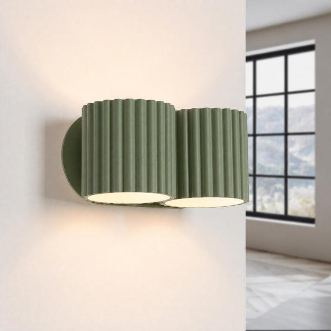 Double Aura wall light in olive green, lit, four beams up and down