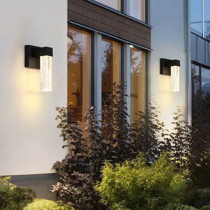 Deux appliques murales noires au cristal à bulles sur une façade moderne au crépuscule