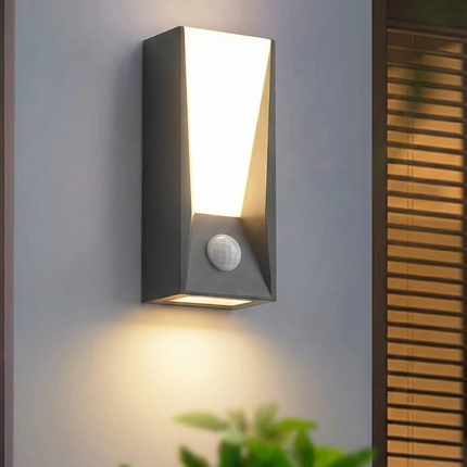 Gros plan d'une applique murale extérieure LED anthracite montrant le détecteur de mouvement PIR et la géométrie trapézoïdale