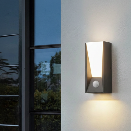 Applique murale extérieure LED anthracite avec détecteur PIR sur un mur blanc, double halo haut et bas au crépuscule