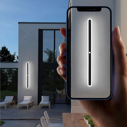 Applique murale extérieure LED noire éclairant une terrasse au crépuscule