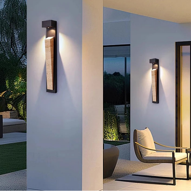 Applique murale extérieure en pierre naturelle et aluminium noir installée sur une façade de jardin