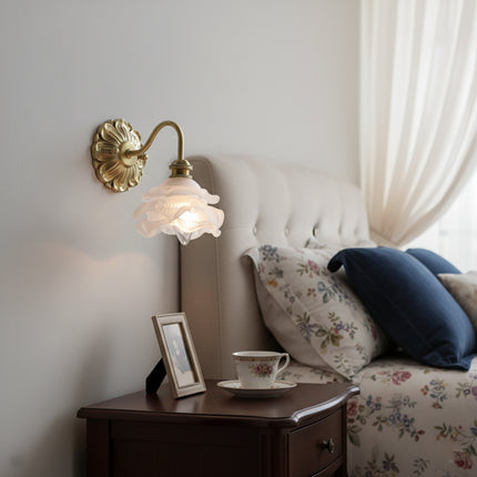 Applique murale fleur en laiton au-dessus d'un chevet dans une chambre romantique aux tons bleus