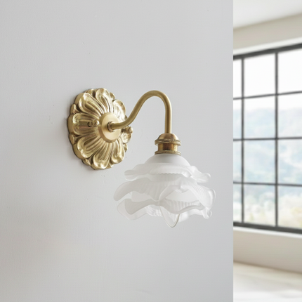 Applique murale fleur en laiton doré et abat-jour en verre dépoli, vue de profil sur mur clair