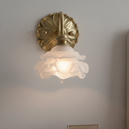 Applique murale fleur allumée diffusant une lumière chaude à travers les pétales de verre dépoli