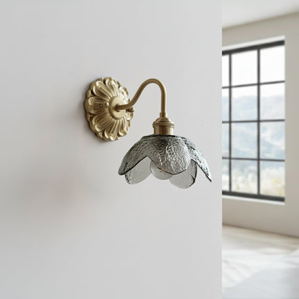 Applique murale fleur en verre fumé foncé et laiton doré, éteinte, vue de trois quarts sur un mur clair