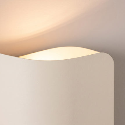 Applique murale Flux Lumineux 30 en acier beige sur fond coloré, vue de trois quarts