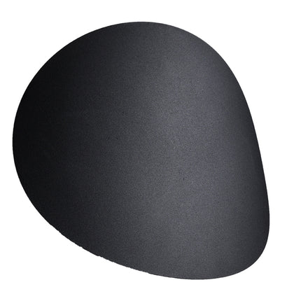 Applique murale galet en acier noir mat fixée sur un mur clair, forme organique