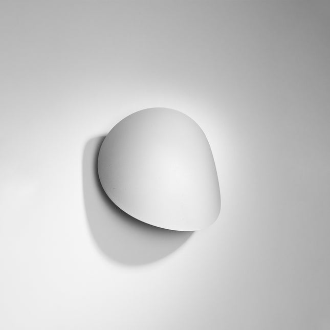 Applique murale galet Ombre Douce blanche vue de face, halo lumineux vertical sur le mur